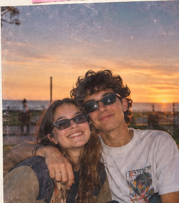 Pareja sonriendo en una fotografía retro al atardecer
